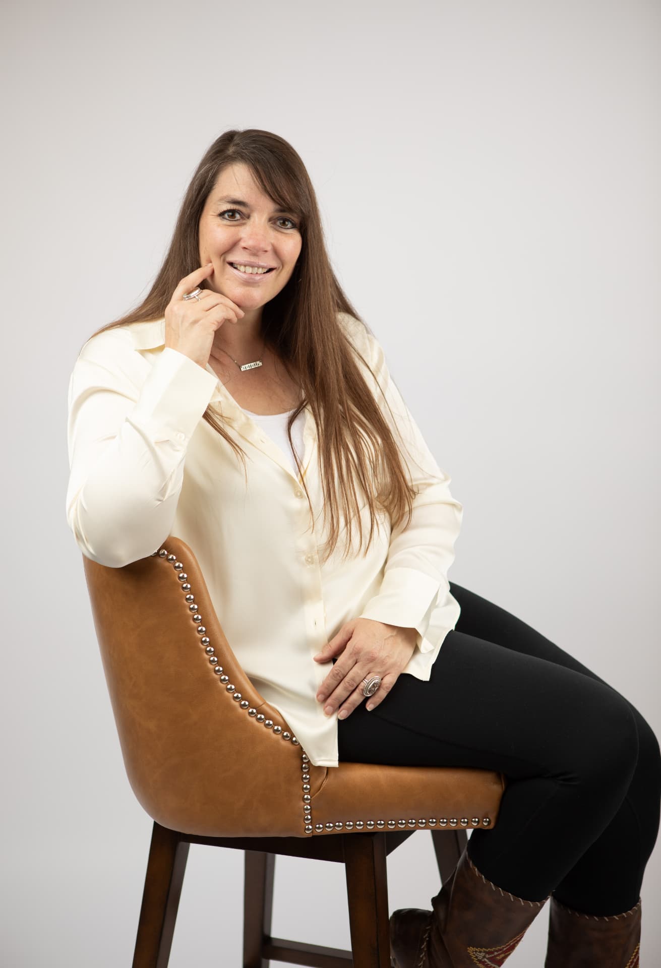 Sara, founder of Soulful Shift, seated in a warm brown chair.